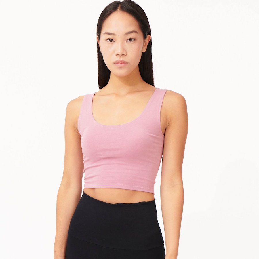 A lady wears a pink fitted crop top by fair trade and sustainable fashion brand Edify.
