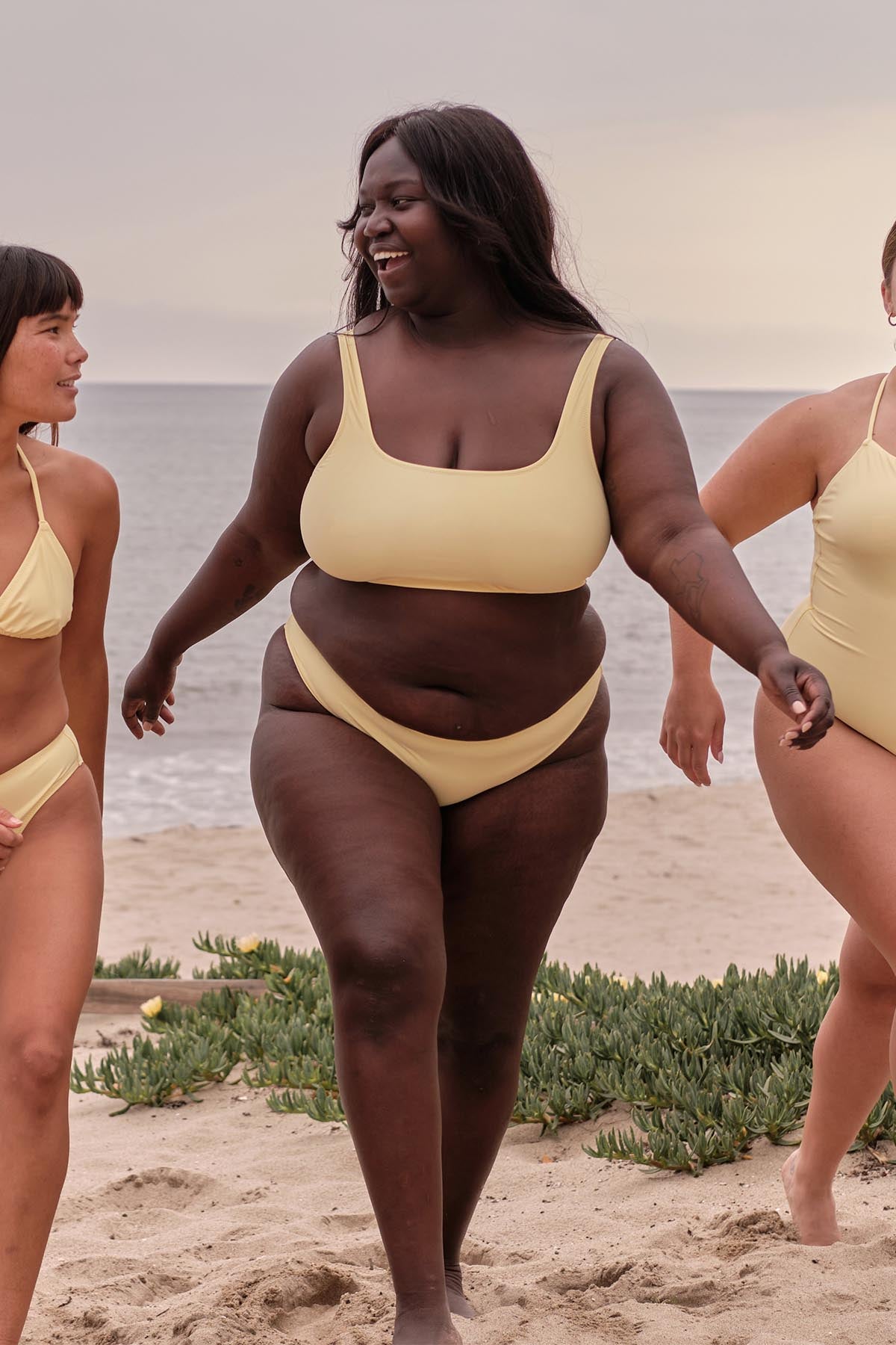 A lady wears a yellow bikini from fair trade, sustainable and size-inclusive fashion brand Girlfriend Collective. 